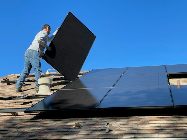 man sitting on white and black solar panel