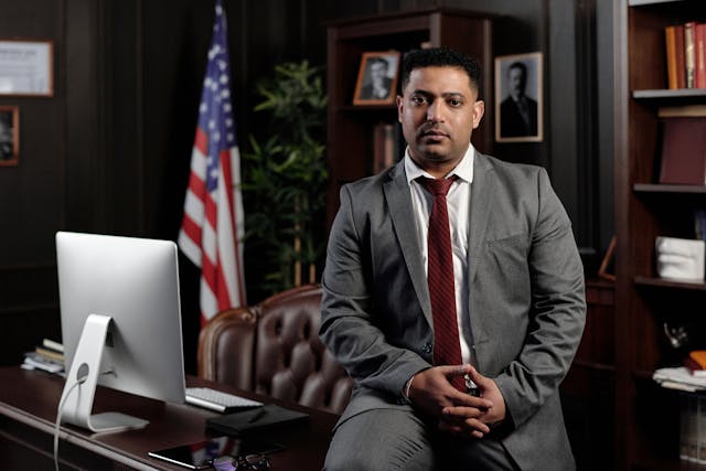 Businessman Sitting on his Desk and Looking at the Camera
